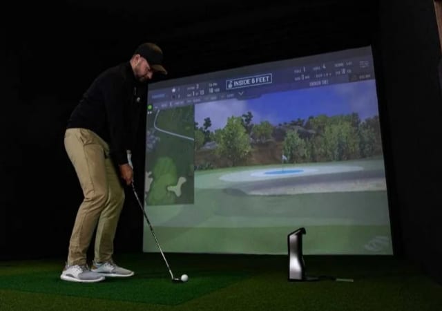 A golfer trying out an indoor golf simulator setup
