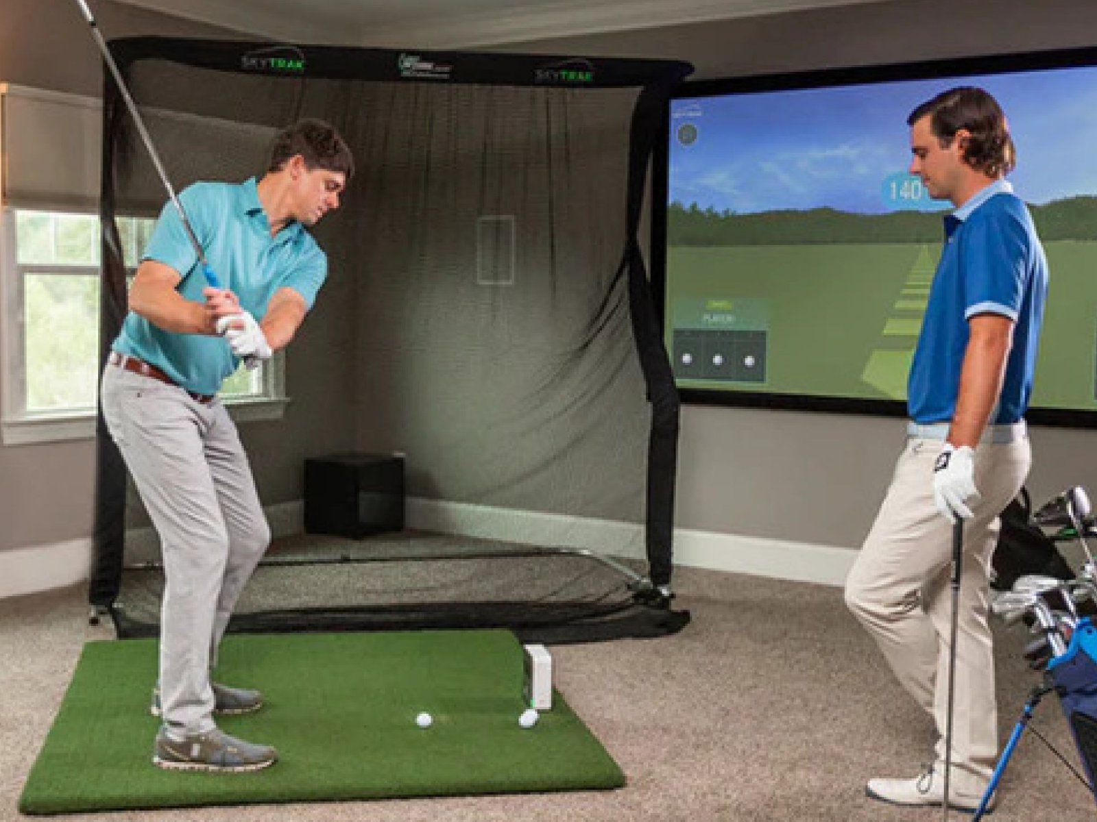 Two golfers using and practicing on a complete indoor golf simulator DIY setup